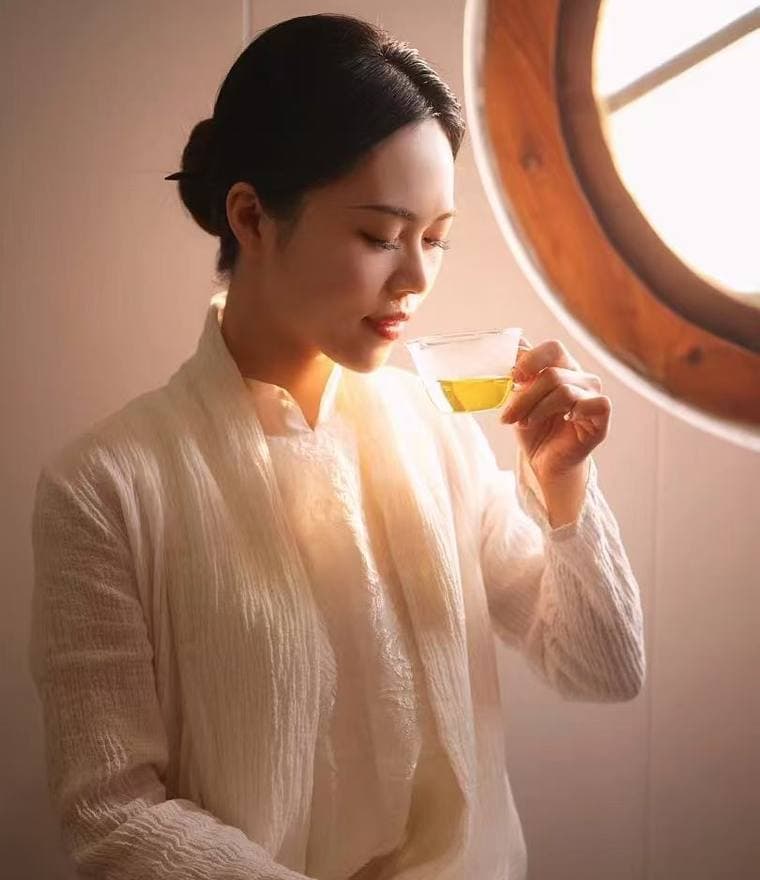 Sara tasting tea by a round window