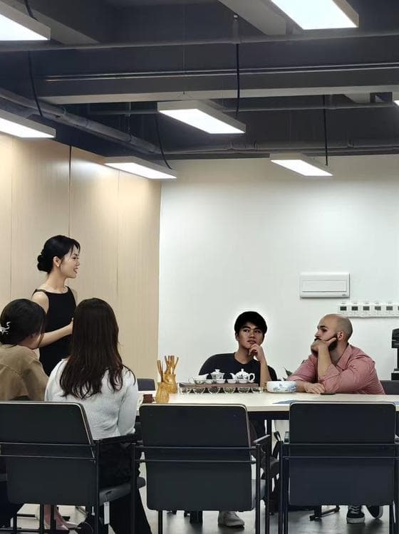 Sara talking about tea with guests around a shared table